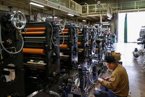 Seorang pekerja memeriksa mesin di sebuah pabrik di Higashiosaka, Jepang