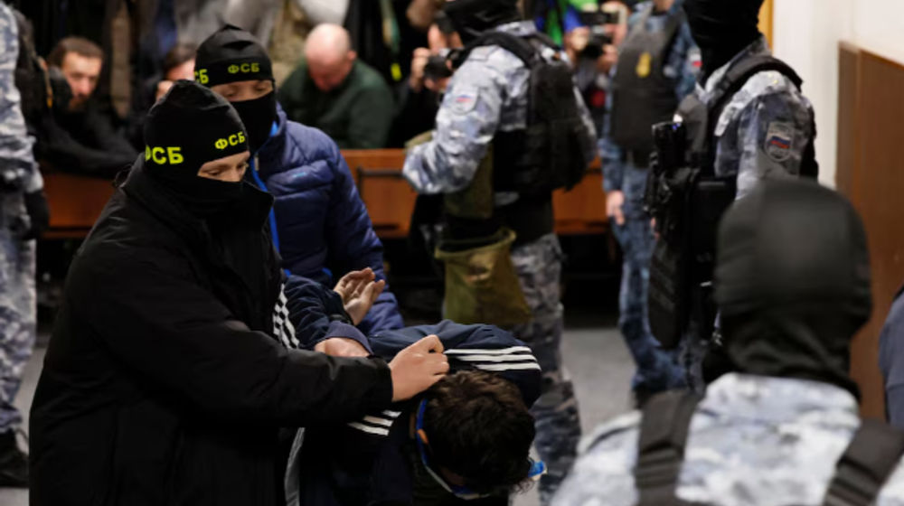 Seorang tersangka penyerangan penembakan di tempat konser Balai Kota Crocus dikawal di dalam pengadilan distrik Basmanny di Moskow, 24 Maret 2024.