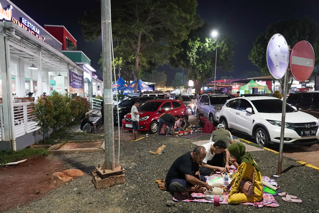 Pemudik menyantap makanan dan beristirahat di rest area KM 102 Cipali, Subang, Jawa Barat. Pada musim mudik, rest area di sepanjang jalan tol Trans Jawa menjadi tempat favorit pemudik beristirahat sejenak. Untuk mengantisipasi kepadatan kendaraan selama masa mudik 2024, para pemudik dihimbau untuk beristirahat maksimal 30 menit rest area. Minggu 7 April 2024. Foto : Panji Asmoro/TrenAsia