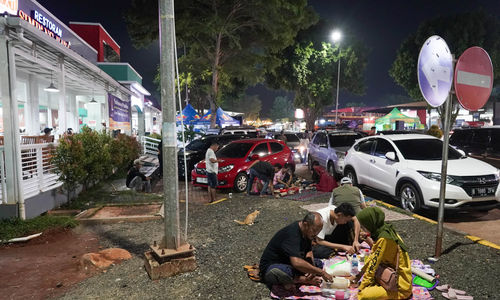 Pemudik menyantap makanan dan beristirahat di rest area KM 102 Cipali, Subang, Jawa Barat. Pada musim mudik, rest area di sepanjang jalan tol Trans Jawa menjadi tempat favorit pemudik beristirahat sejenak. Untuk mengantisipasi kepadatan kendaraan selama masa mudik 2024, para pemudik dihimbau untuk beristirahat maksimal 30 menit rest area. Minggu 7 April 2024. Foto : Panji Asmoro/TrenAsia