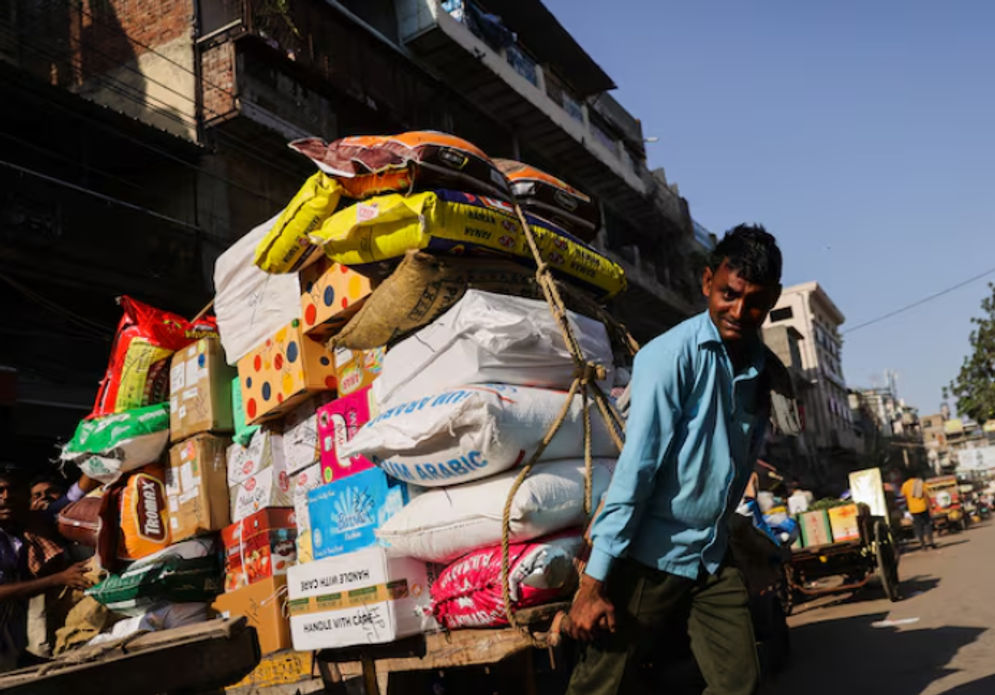 Seorang buruh mengangkut gerobak penuh karung di pasar grosir di kawasan tua Delhi, India