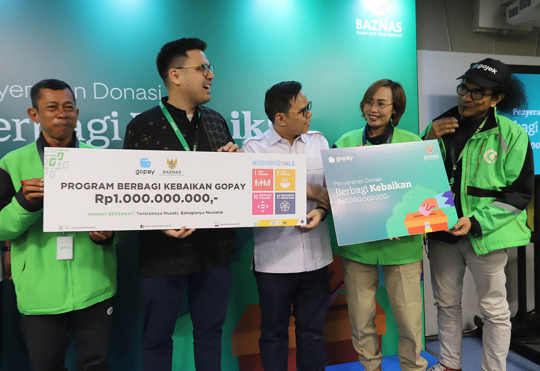 Head of Regulatory and Public Affairs GoTo Financial Budi Gandasoebrata (kedua kiri) secara simbolis menyerahkan donasi kepada Pimpinan Bidang Pengumpulan BAZNAS Rizaludin Kurniawan, M.Si. CFRM dan para perwakilan komunitas mitra driver Gojek di Jakarta, Selasa 23 April 2024. Foto : Panji Asmoro/TrenAsia