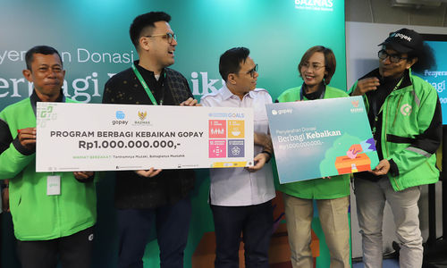 Head of Regulatory and Public Affairs GoTo Financial Budi Gandasoebrata (kedua kiri) secara simbolis menyerahkan donasi kepada Pimpinan Bidang Pengumpulan BAZNAS Rizaludin Kurniawan, M.Si. CFRM dan para perwakilan komunitas mitra driver Gojek di Jakarta, Selasa 23 April 2024. Foto : Panji Asmoro/TrenAsia