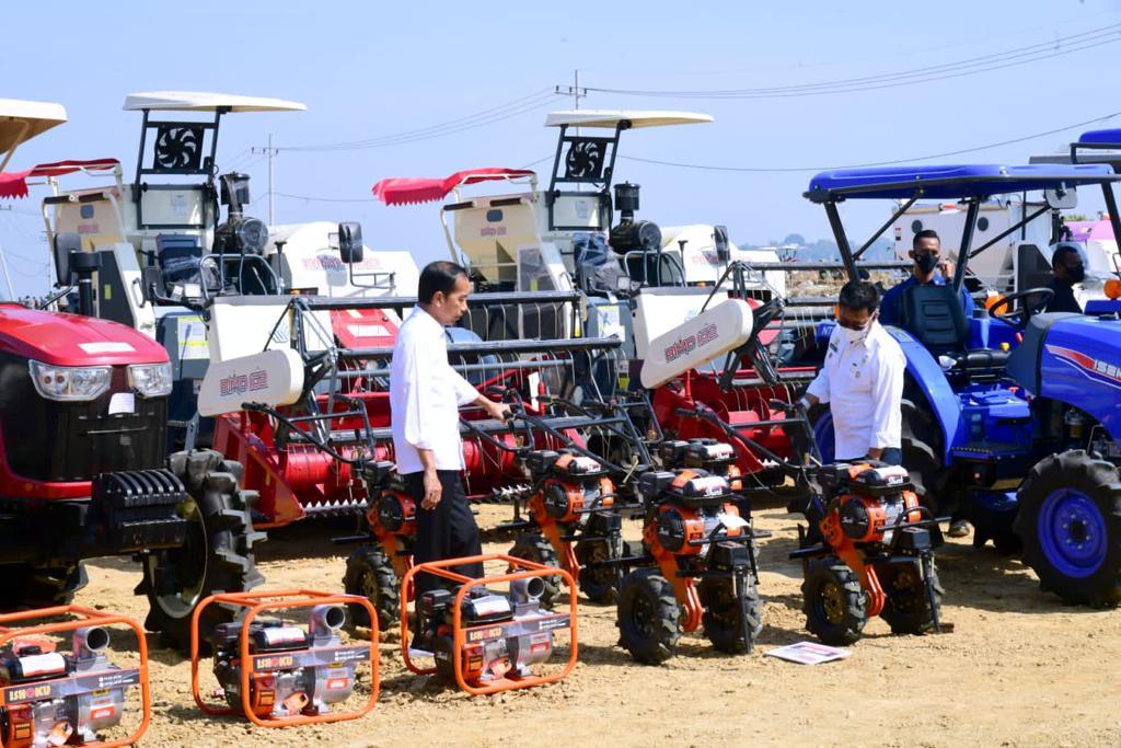 Presiden Jokowi memamerkan mesin pertanian, berupa rice mill unit (RMU), dryer, combine harvester, traktor bantuan kepada petani Indonesia. 