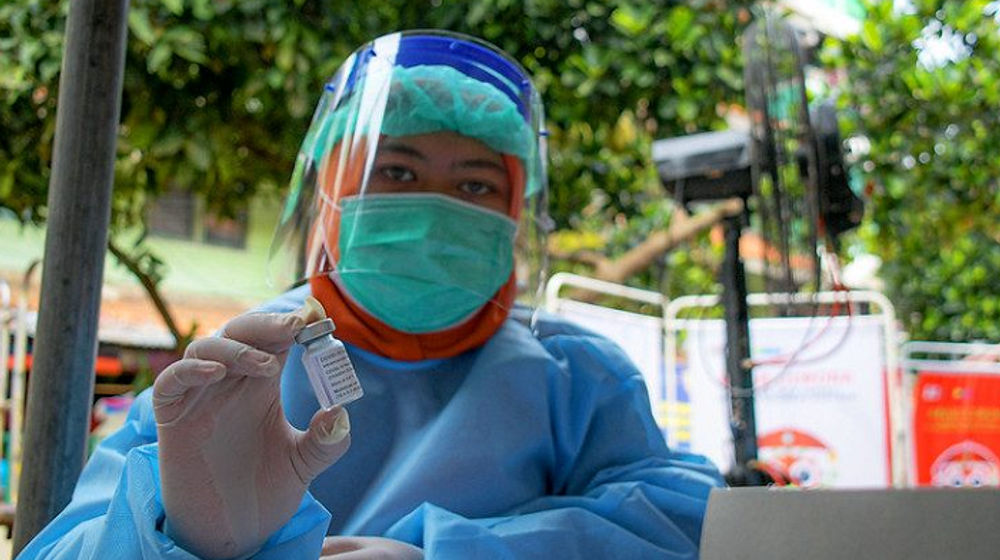 Potret petugas kesehatan memegang vaksin.