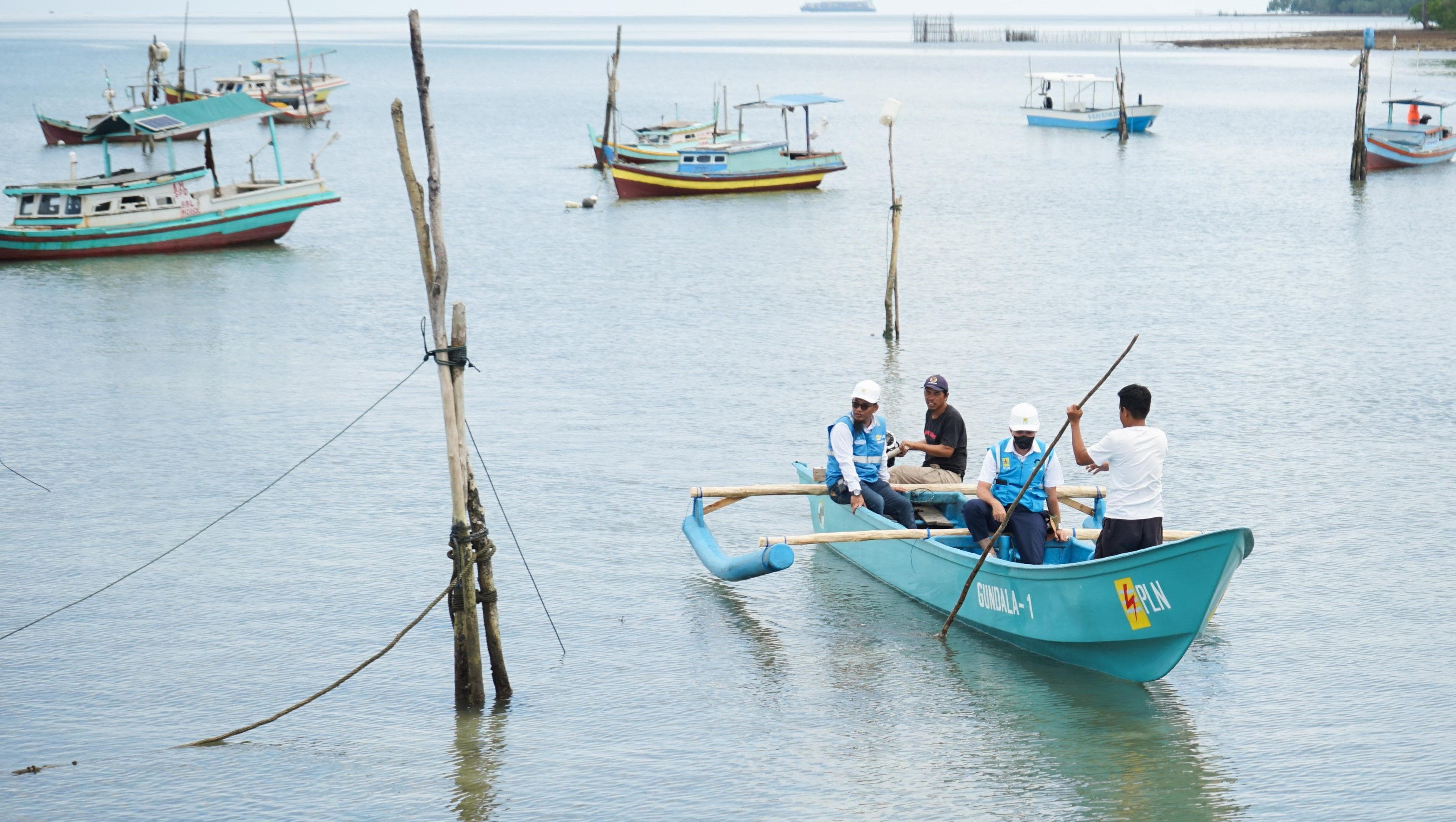 Petugas PLN melakukan uji coba bantuan mesin perahu listrik di dermaga pelabuhan nelayan Desa Suak Gual