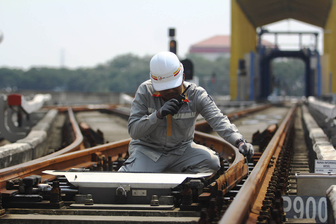 Nampak sejumlah petugas sedang melakukan pengecekan arus listrik pada jalur rel di Area Depo LRT Jakarta, di kawasan depo Pegangsaan Dua, Jakarta Utara. 10 Mei 2024. Foto : Panji Asmoro/TrenAsia