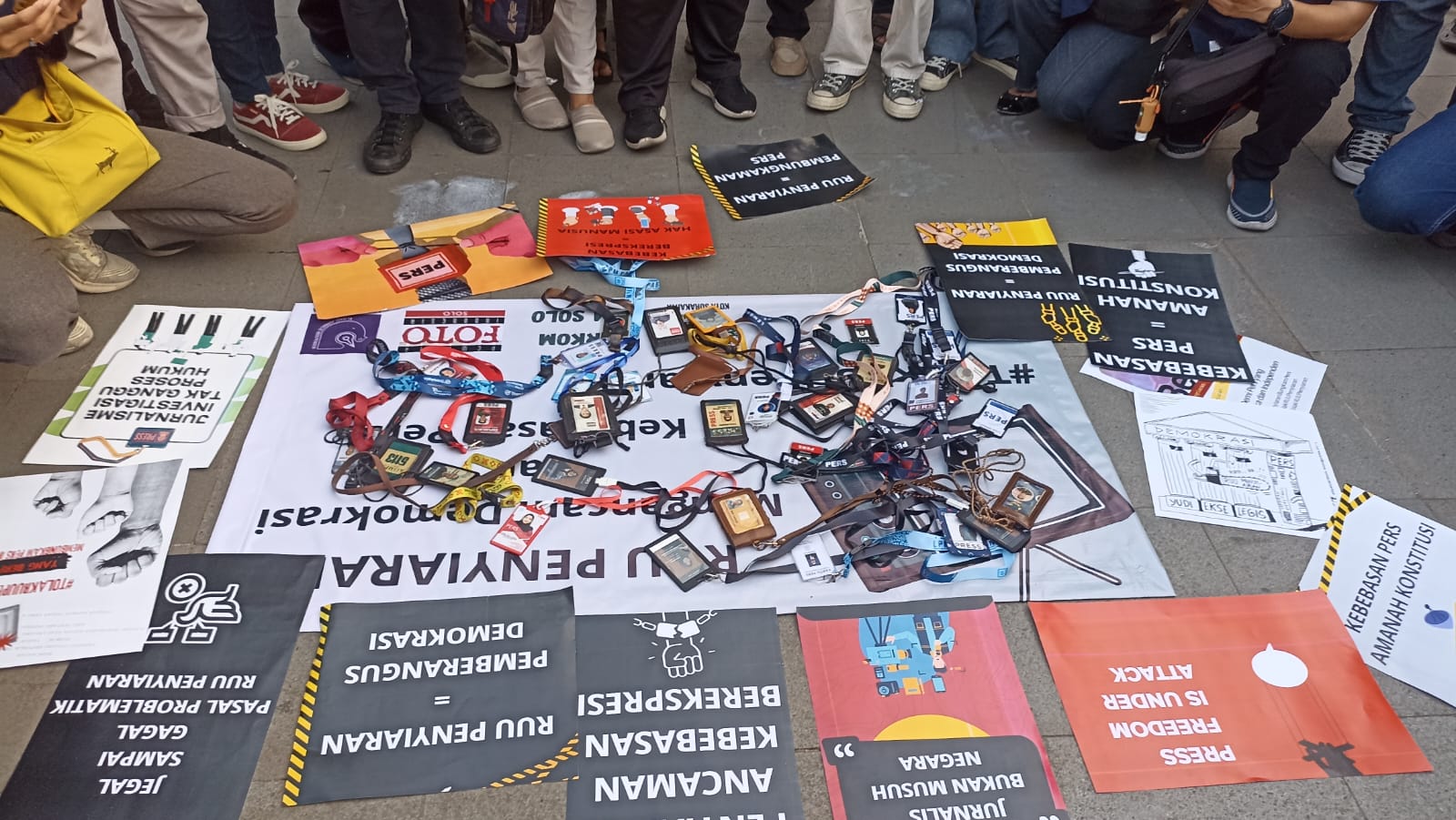 Para jurnalis di Solo menanggalkan kartu persnya sebagai bentuk protes atas pembahasan RUU Penyiaran di Plaza Manahan, Selasa 21 Mei 2024. 