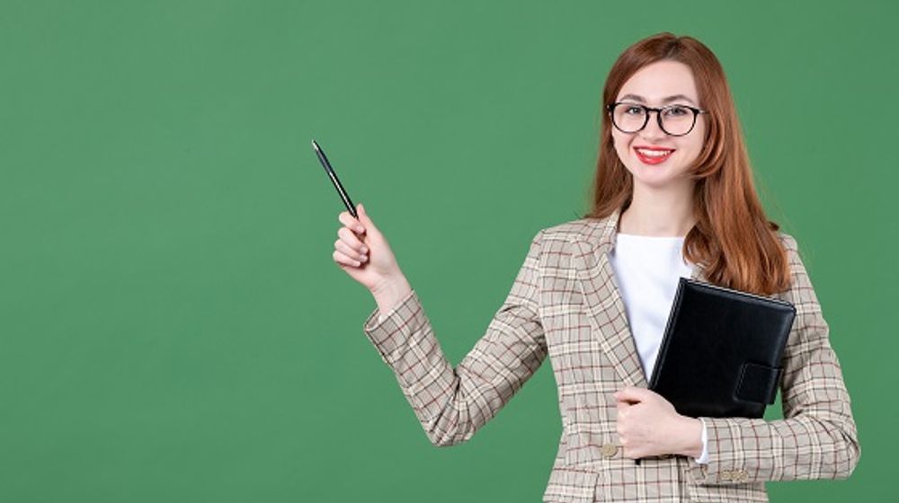 portrait-female-teacher-holding-notepad-green.jpg
