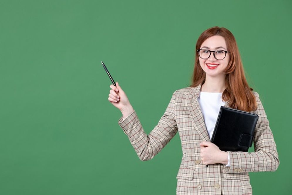 portrait-female-teacher-holding-notepad-green.jpg