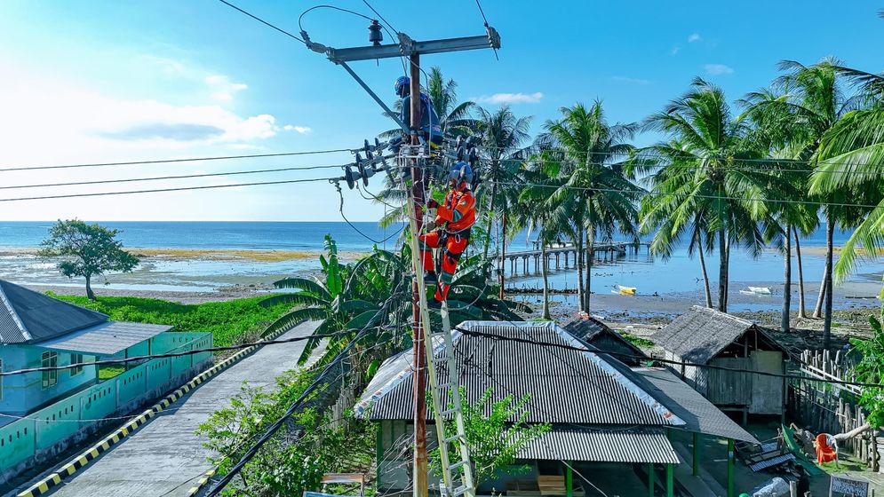Petugas PLN melakukan penggantian material jaringan listrik untuk meningkatkan layanan listrik dari 12 jam menjadi 24 jam di Desa Sebotok, Sumbawa.