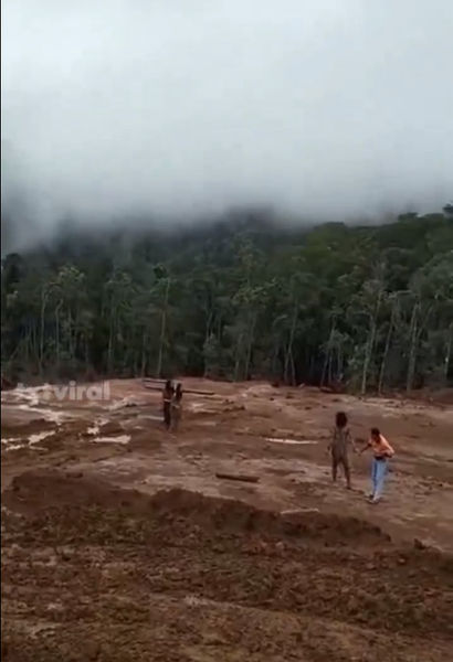 Terlihat satu pria dan dua wanita dari Suku Togutil mendekati area tambang.