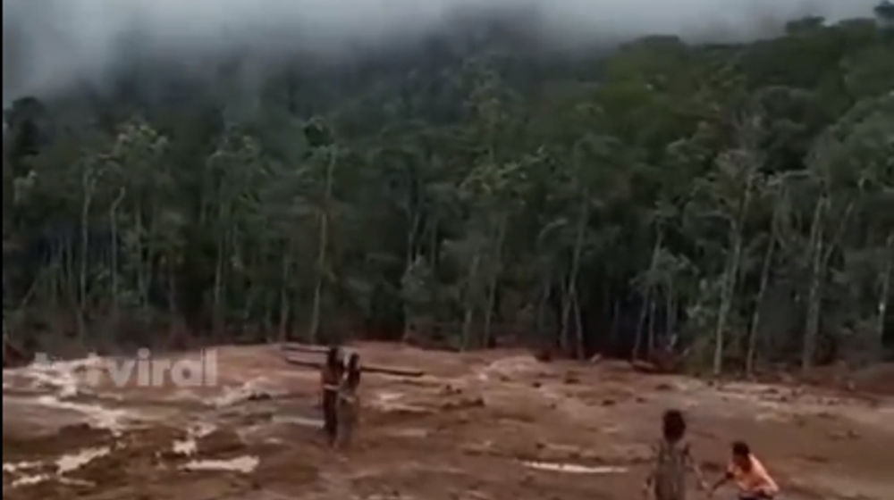 Terlihat satu pria dan dua wanita dari Suku Togutil mendekati area tambang.