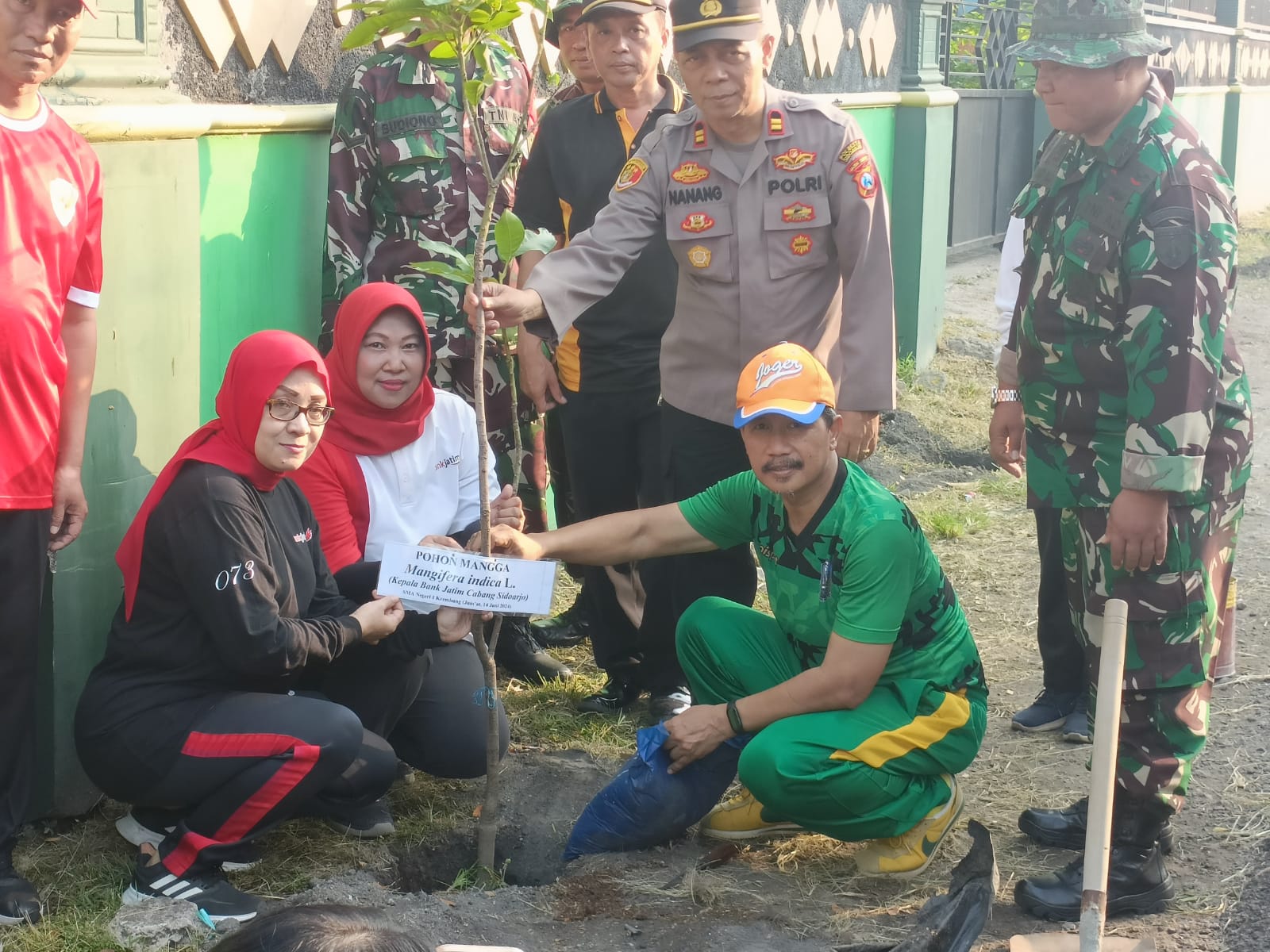 Kepala Sekolah SMAN 1 Krembung, Kabupaten Sidoarjo, Suswanto (kanan bawah) saat melakukan penanaman pohon mangga di depan sekolah bersama Muspika Krembung serta perwakilan undangan.