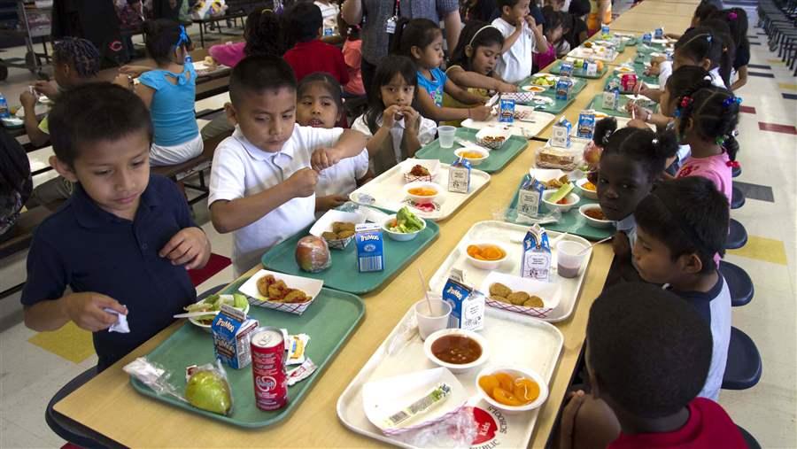 Ilustrasi anak SD makan di sekolah.