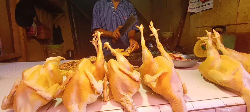 Pedagang ayam kampung sedang melayani pembeli