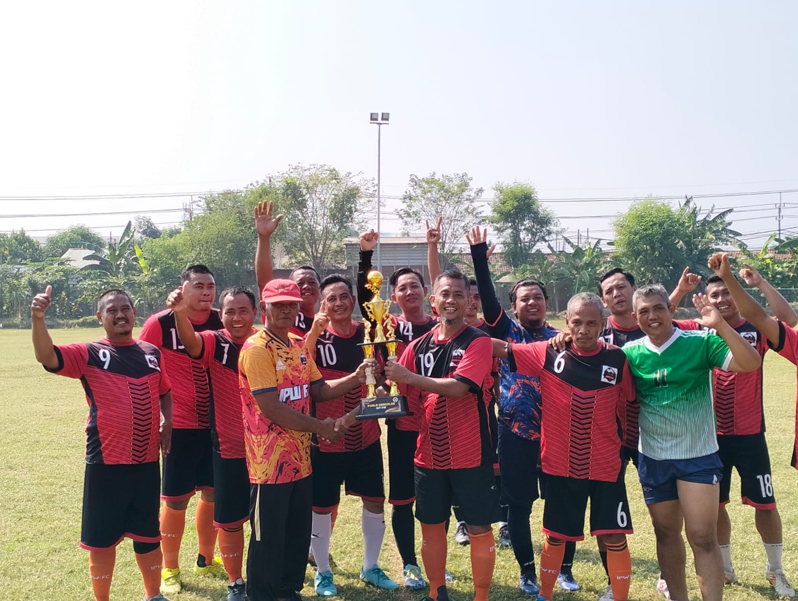 Tim Merah mengangkat trofi usai memastikan menjadi juara fourfeo Ultah II IPW di Lapangan Sadang, Taman, Sidoarjo, Minggu pagi (28/7/2024).