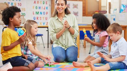 Ilustrasi staff bermain dengan anak di daycare.