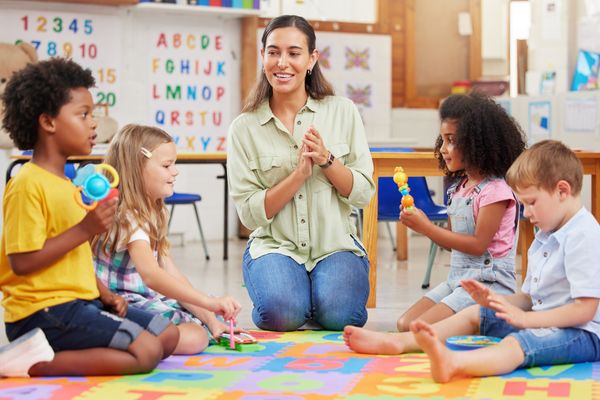 Ilustrasi staff bermain dengan anak di daycare.