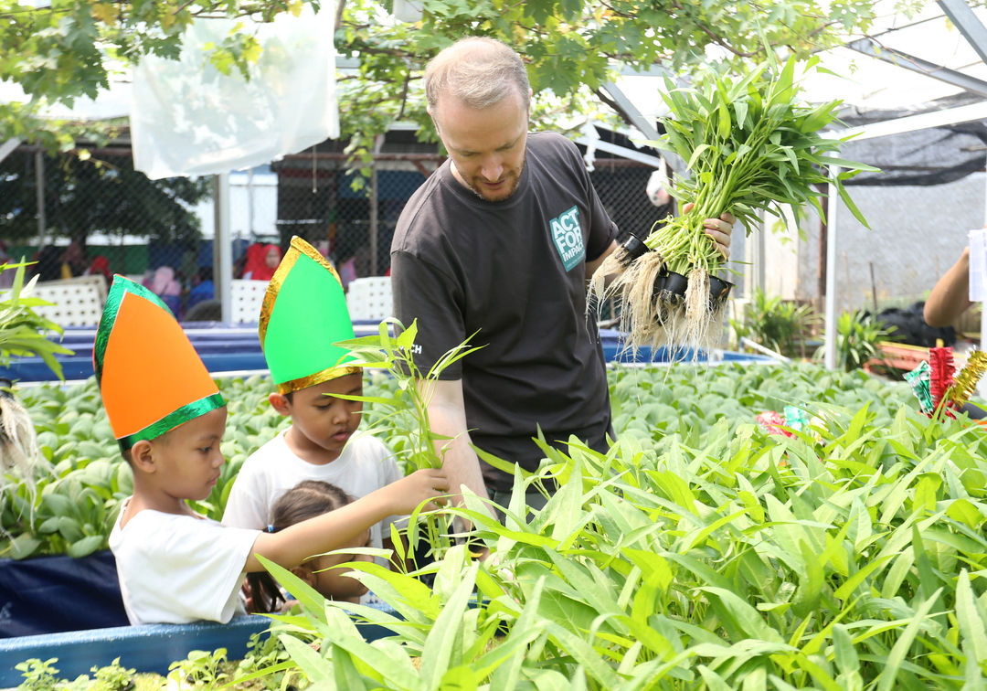 Managing Director of Bosch in Indonesia Pirmin Riegger memanen kangkung bersama anak-anak disela penyerahan donasi  untuk Program Asah Asih Asuh di PAUD Kenanga 7, Jakarta Barat, Kamis 15 Agustus 2024. Foto : Panji Asmoro/TrenAsia
