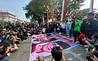 Demonstran membentangkan banner besar yang isinya menyindir dinasti Jokowi dalam aksi di Balai Kota Solo, Kamis, 22 Agustus 2024. (Kredit AJI)