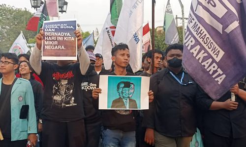 Demonstran membawa poster yang isinya menyindir pemerintahan Joko Widodo dalam aksi di Balai Kota Solo,  Kamis, 22 Agustus 2024. (Chrisna Chanis Cara/TrenAsia)