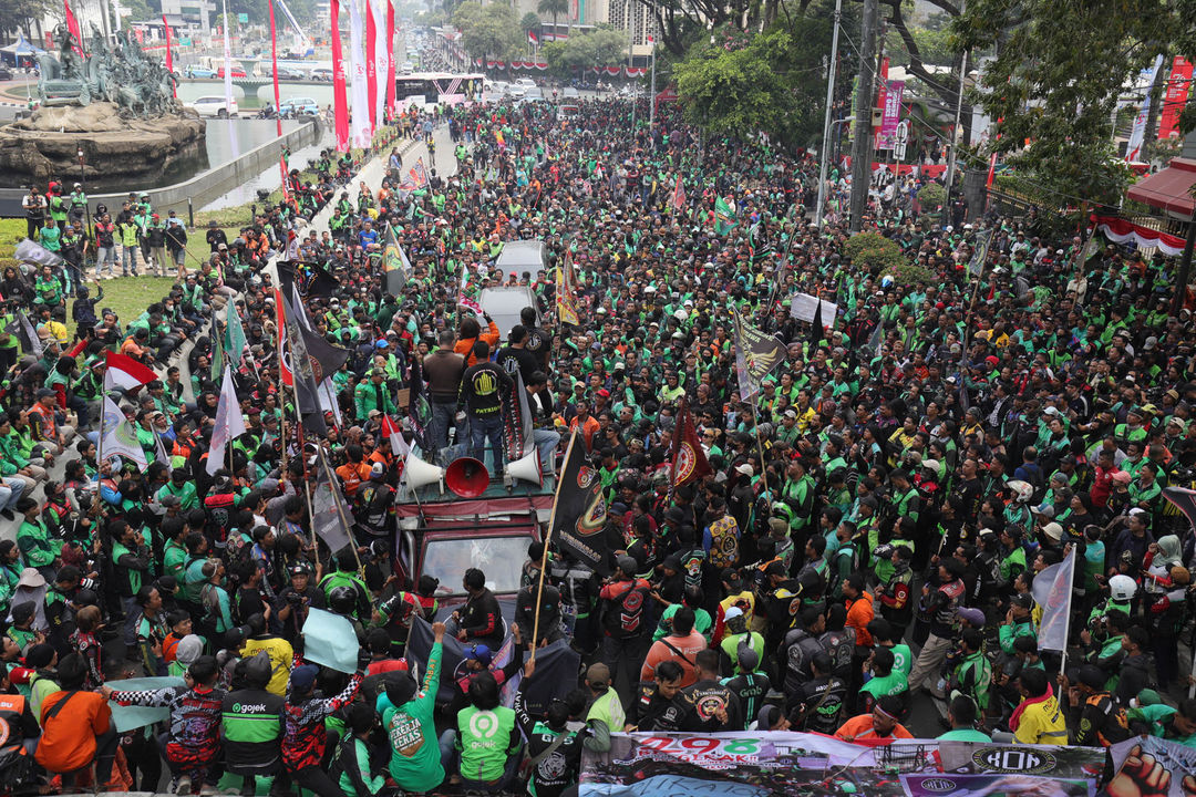 Massa yang tergabung dalam Koalisi Ojol Nasional (KON)melakukan aksi damai dikawasan Jl Medan Merdeka. Mereka menyampaikan sejumlah tuntutan di antaranya meminta pemerintah untuk melegalkan ojek daring dan menuntut revisi serta penambahan Pasal Permenkominfo No 1 Tahun 2012 tentang layanan tarif pos komersial untuk mitra ojek daring dan kurir di Indonesia lebih rinci. Kamis 29 Agustus 2024. Foto : Panji Asmoro/TrenAsia