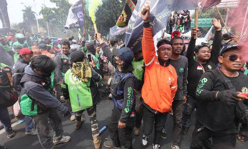 Massa yang tergabung dalam Koalisi Ojol Nasional (KON)melakukan aksi damai dikawasan Jl Medan Merdeka. Mereka menyampaikan sejumlah tuntutan di antaranya meminta pemerintah untuk melegalkan ojek daring dan menuntut revisi serta penambahan Pasal Permenkominfo No 1 Tahun 2012 tentang layanan tarif pos komersial untuk mitra ojek daring dan kurir di Indonesia lebih rinci. Kamis 29 Agustus 2024. Foto : Panji Asmoro/TrenAsia