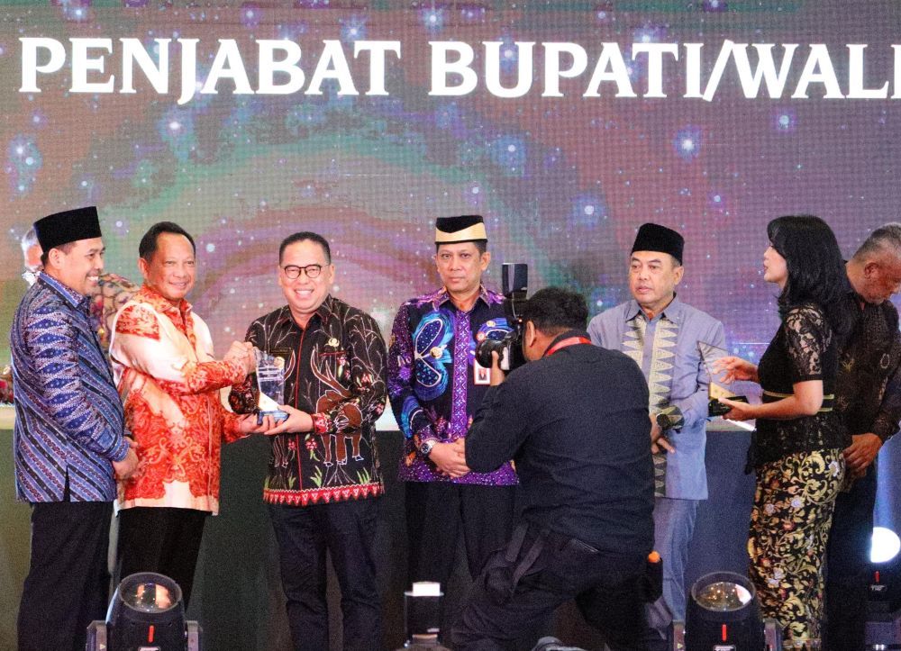 Mendagri Tito Karnavian menyerahkan penghargaan kepada Pj Bupati PPU, Makmur Marbun.