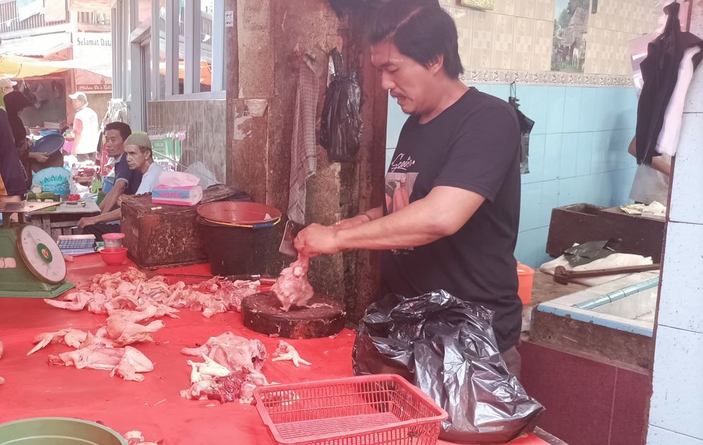 Seorang pedagang ayam sedang melayani pembeli di Pasar 26 Ilir Palembang