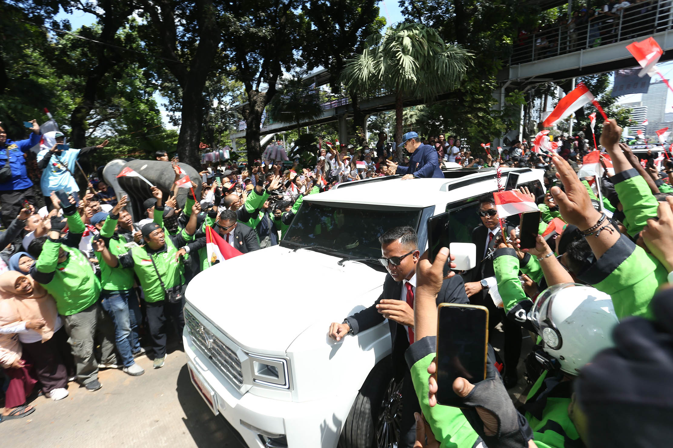 Nampak ratusan driver Gojek turut antusias bersama masyarakat menyambut arak-arakan presiden terpilih di kawasan Patung Kuda, Minggu 20 Oktober 2024. Foto : Panji Asmoro/TrenAsia