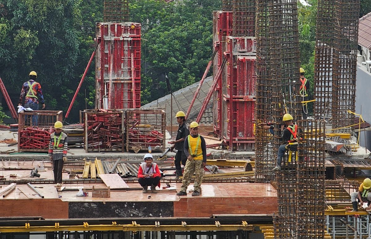 Sejumlah pekerja sektor konstruksi tengah membangun gedung. Apindo mempertanyakan dasar penghitungan UMP 2025.