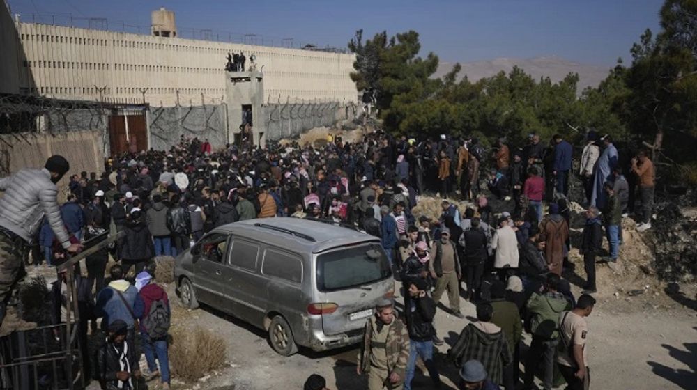 Orang-orang berdiri di luar penjara militer Saydnaya yang terkenal, tepat di utara Damaskus, Suriah, Senin, 9 Desember 2024.