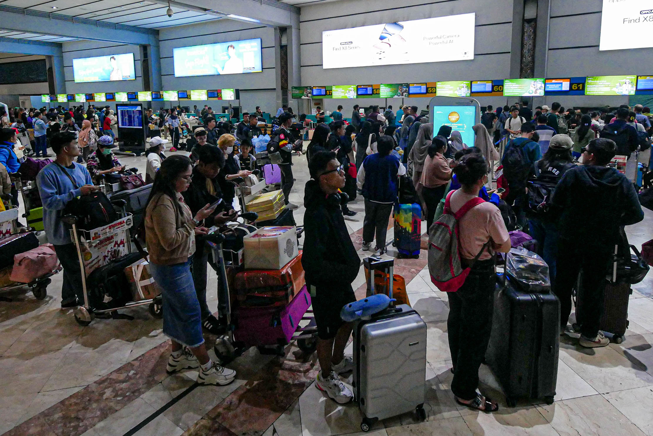 Nampak kepadatan penumpang di Bandara Soekarno Hatta jelang libur Natal dan Tahun Baru 2025. Untuk tahun ini kepadatan penumpang diprediksi meningkat sekitar 6 % dibanding tahun lalu. Foto : Panji Asmoro/TrenAsia