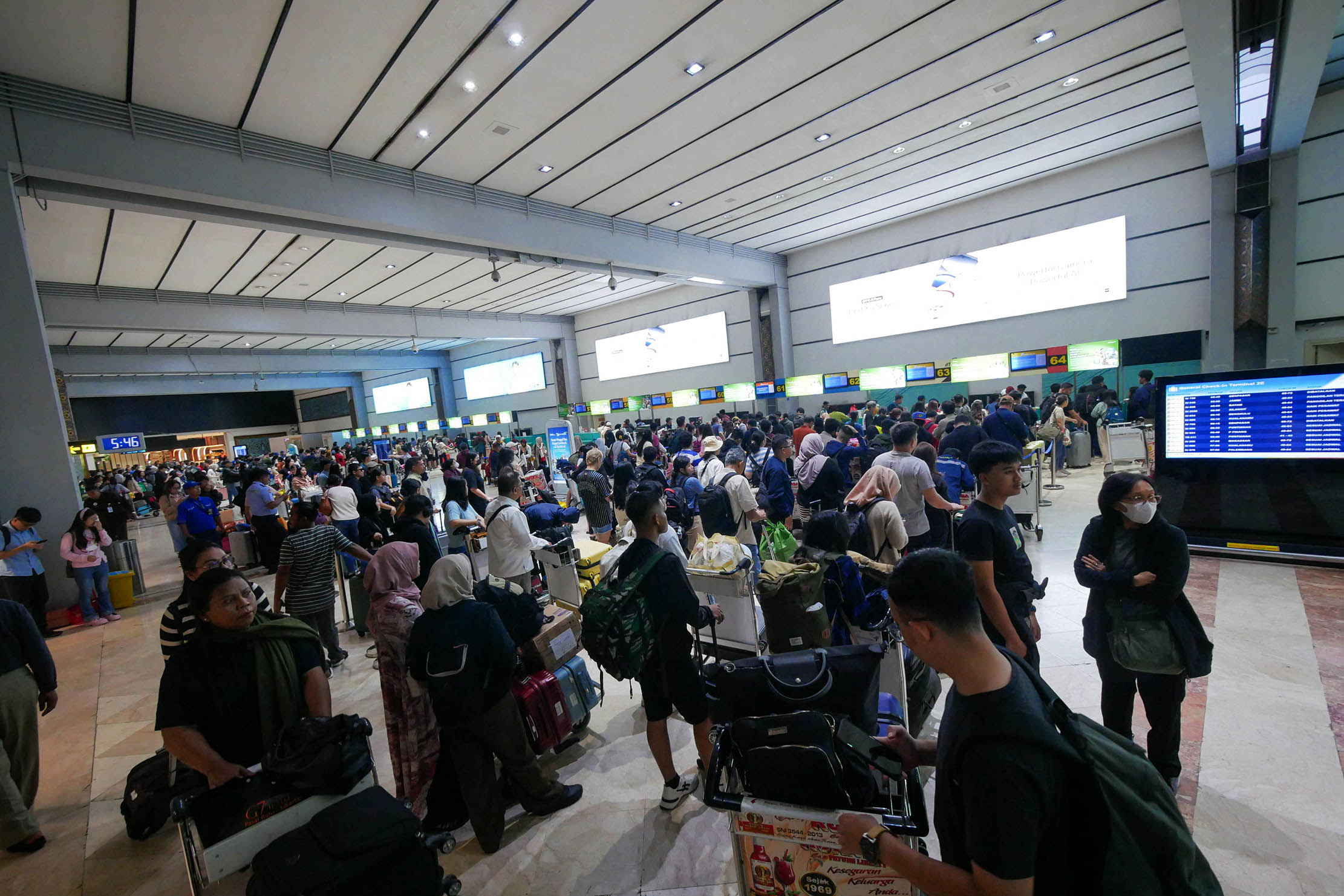 Nampak kepadatan penumpang di Bandara Soekarno Hatta jelang libur Natal dan Tahun Baru 2025. Untuk tahun ini kepadatan penumpang diprediksi meningkat sekitar 6 % dibanding tahun lalu. Foto : Panji Asmoro/TrenAsia