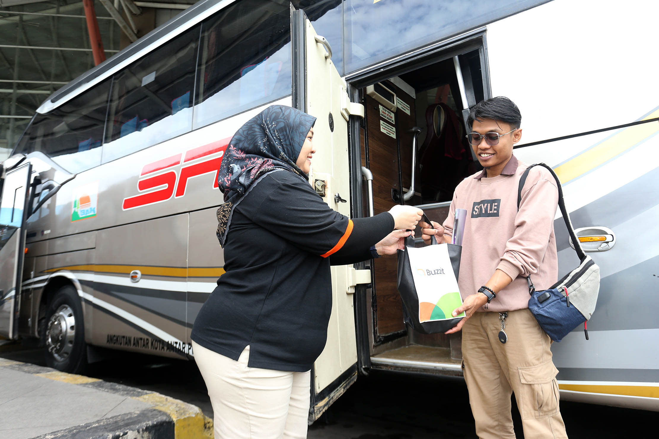 Wakil Direktur Perusahaan Otobus Siliwangi Antar Nusa (PO. SAN) Kurnia Lesari Adnan membagikan bingkisan berupa snack dan kalender kepada para penumpang bus PO.SAN di Terminal Terpadu Pulo Gebang , Jakarta Timur, Selasa 31 Desember 2024. Foto : Panji Asmoro/TrenAsia