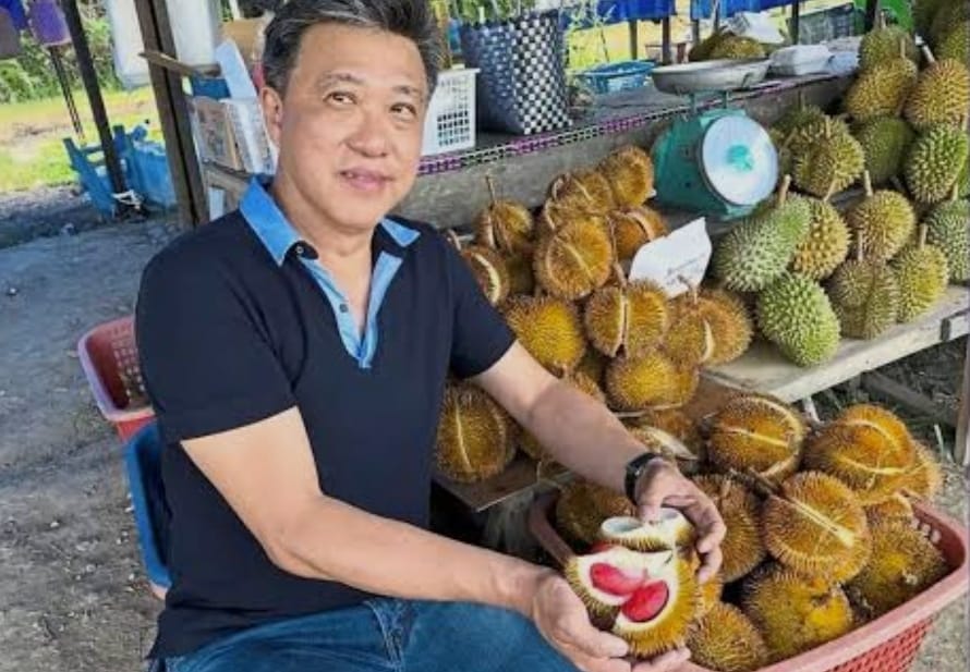 Seorang pembeli durian memperlihatkan durian merah yang disebut tabelak.