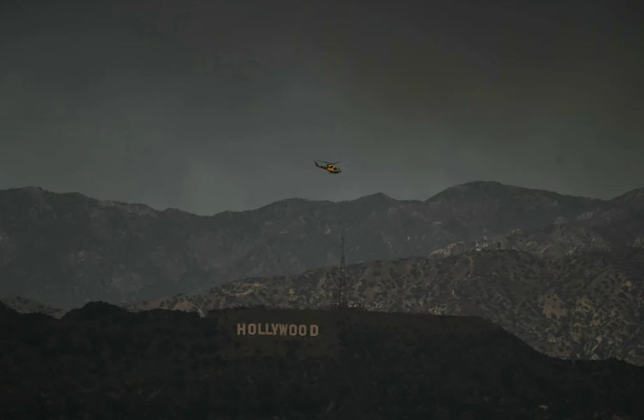 Helikopter pemadam kebakaran terbang di atas tanda Hollywood pada hari Rabu, 8 Januari.