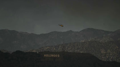 Helikopter pemadam kebakaran terbang di atas tanda Hollywood pada hari Rabu, 8 Januari.