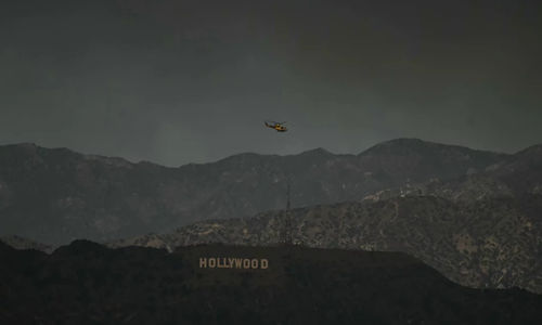 Helikopter pemadam kebakaran terbang di atas tanda Hollywood pada hari Rabu, 8 Januari.