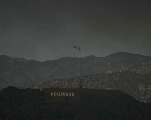 Helikopter pemadam kebakaran terbang di atas tanda Hollywood pada hari Rabu, 8 Januari.