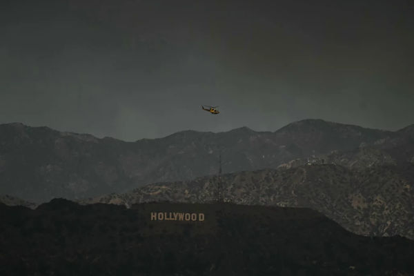 Helikopter pemadam kebakaran terbang di atas tanda Hollywood pada hari Rabu, 8 Januari.