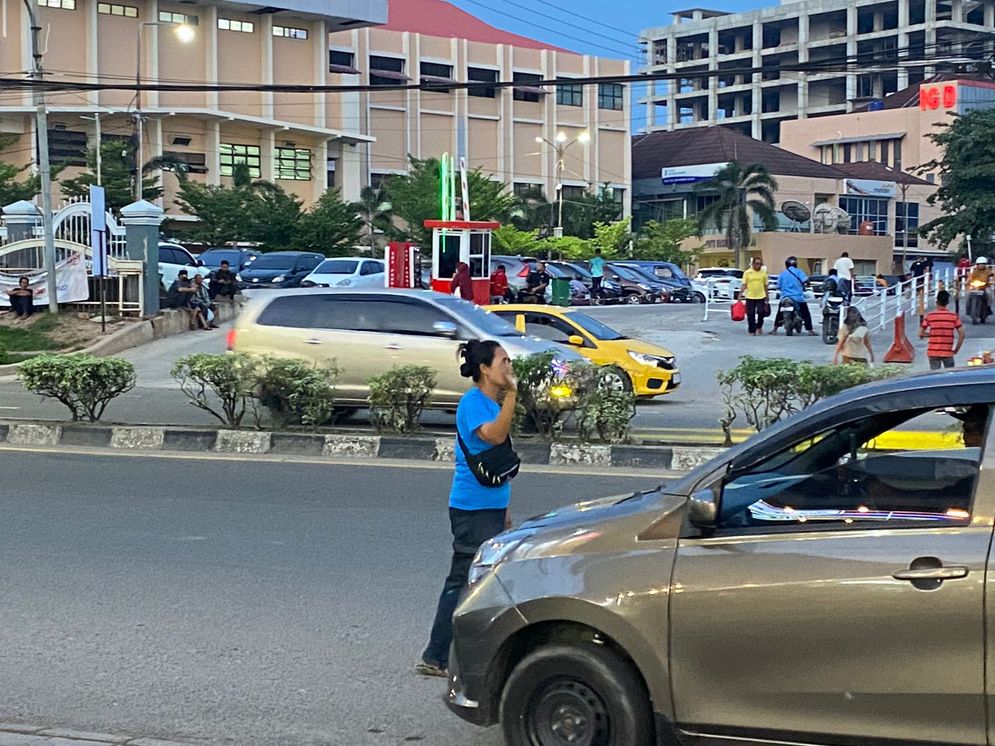 Reni saat mengatur parkir  kendaraan di kawasan Jalan Sudirman Palembang, Senin (13/1/2025)