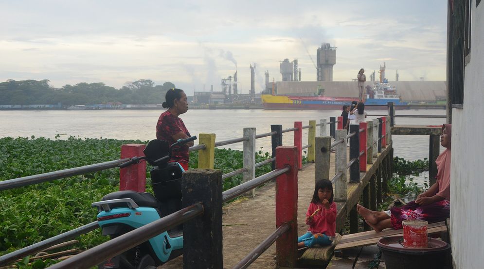 Fauziah dan keluarga bersantai bersama tetangganya pada Selasa sore (25/2/2025), rumah mereka tepat  berada di seberang Pabrik Pupuk Sriwidjaja Palembang