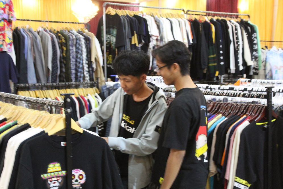 Pengunjung Festival Thrift Hari Raya 2025 memilih pakaian yang ditawarkan penjual