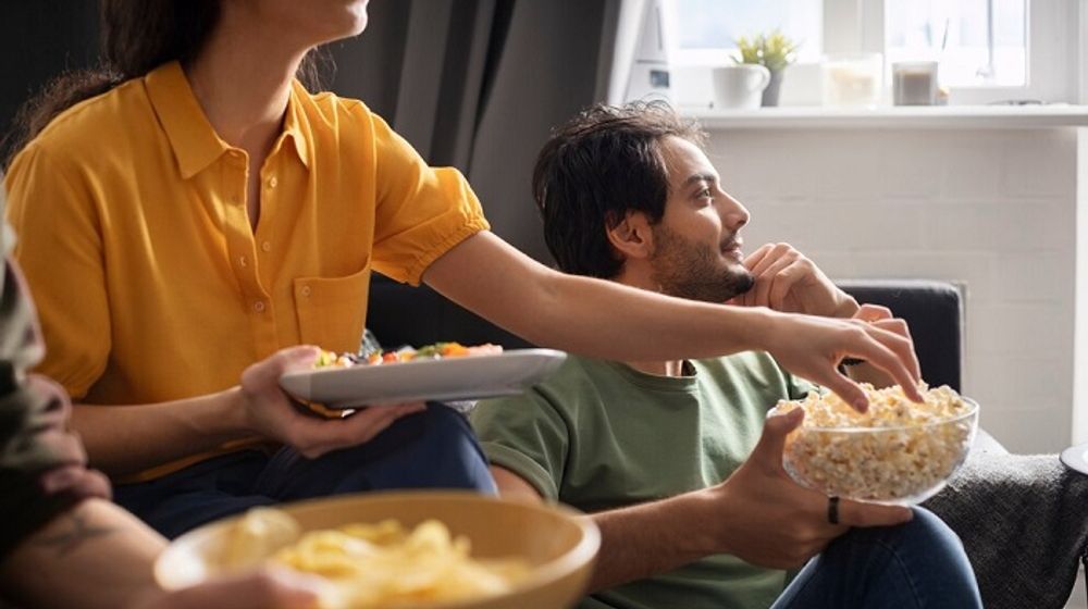 Ilustrasi nonton film/k-drama di rumah sambil menikmati camilan.