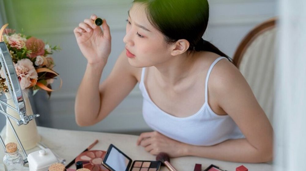 Ilustrasi wanita sedang menggunakan makeup.