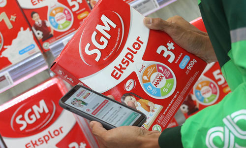 Mitra Pengemudi Grab tengah melakukan transaksi pembelian susu pertumbuhan SGM Eksplor di gerai Alfamart, dengan memanfaatkan voucher diskon dalam program Hadiah Lebaran untuk Pejuang Keluarga. Rabu 9 April 2025. Foto : Panji Asmoro/TrenAsia