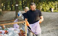 Seorang laki-laki dan perempuan sedang memilah sampah.