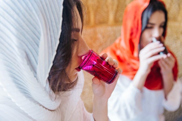 Ilustrasi wanita muslim sedang minum.